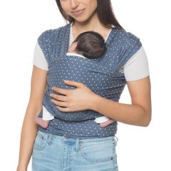 Mamma bär barnet med mage inåt i Aura Wrap Coral Dots bärsele
