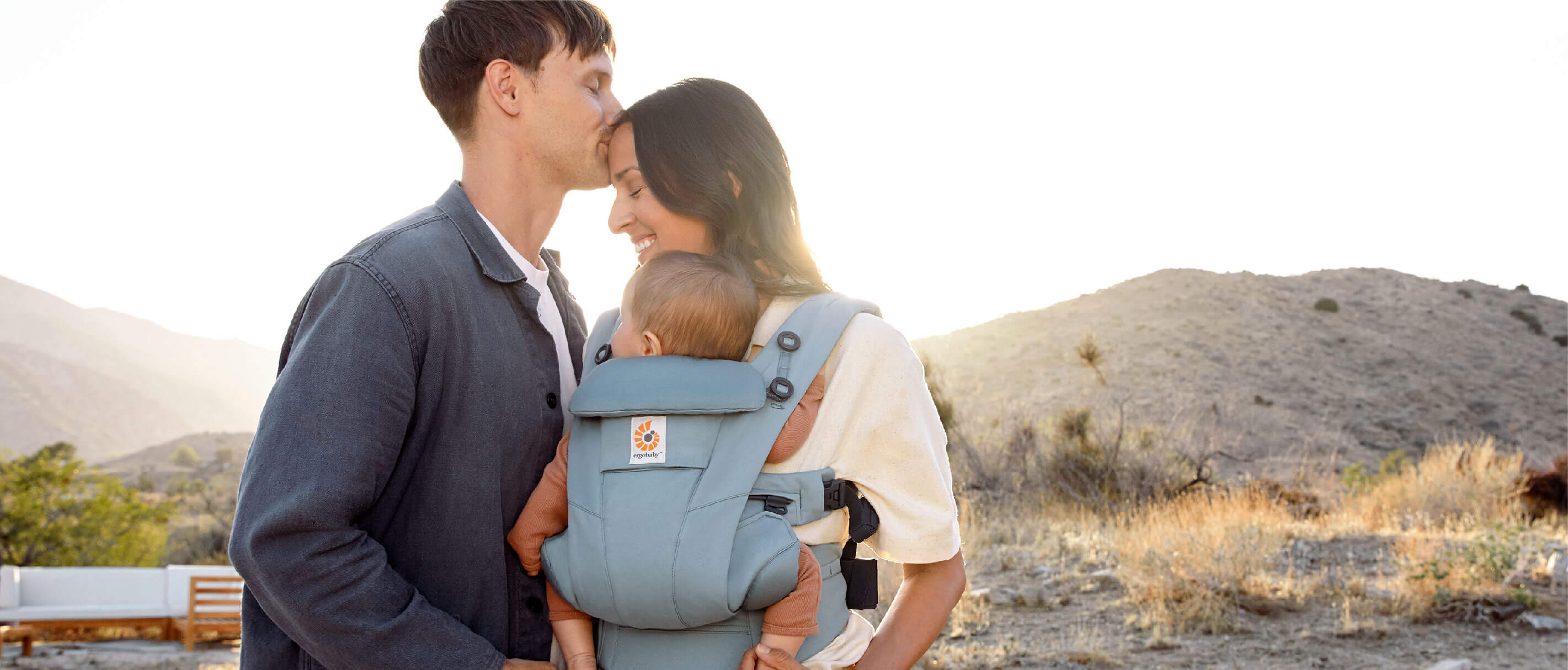 Photo parent carrying child in Omni Breeze carrier outward facing
